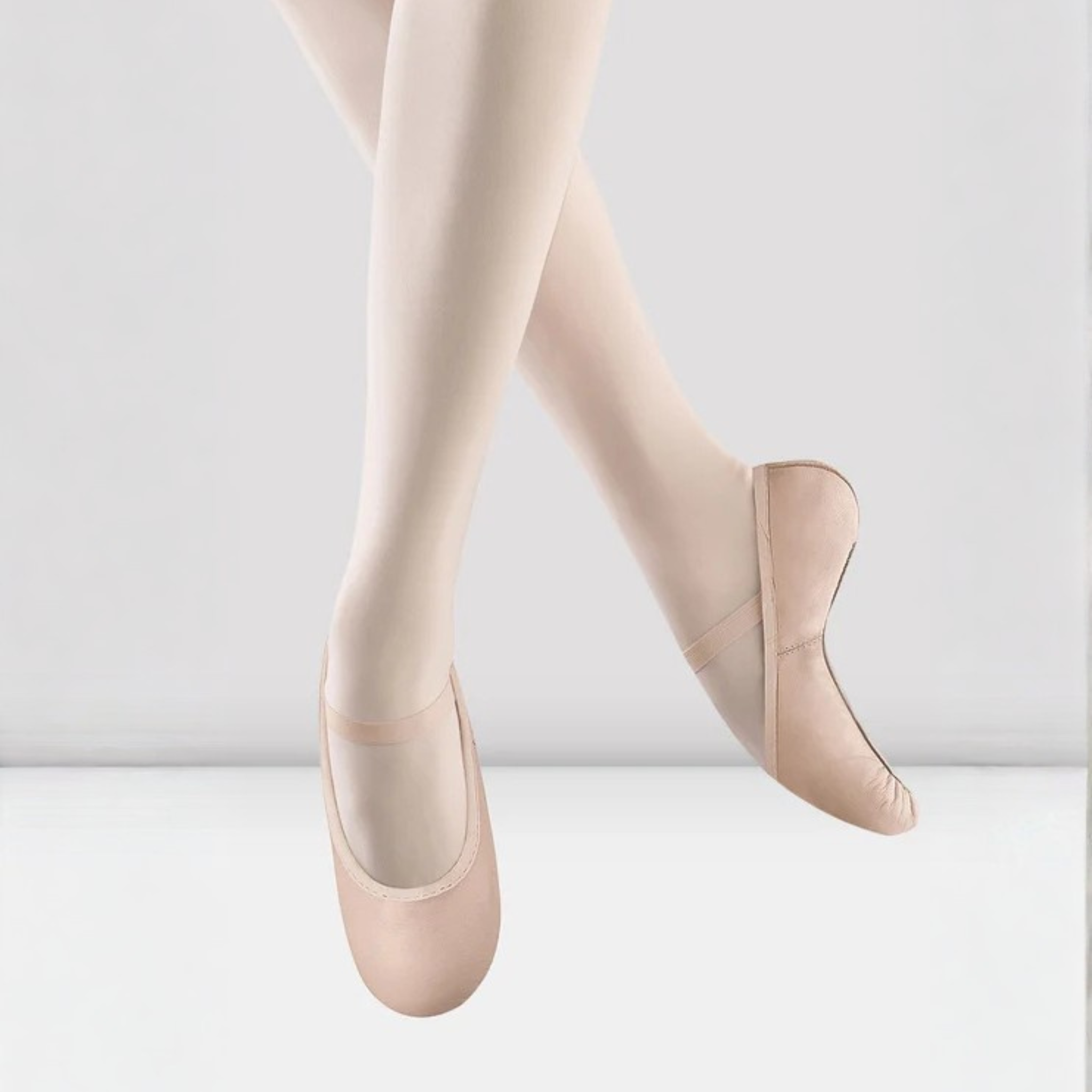 Bloch S0227G Children Belle Leather Ballet Shoe Side and Front View. The inside displays a white fabric with pink small hearts throughout. In addition, this style is full sole and has one elastic strap.