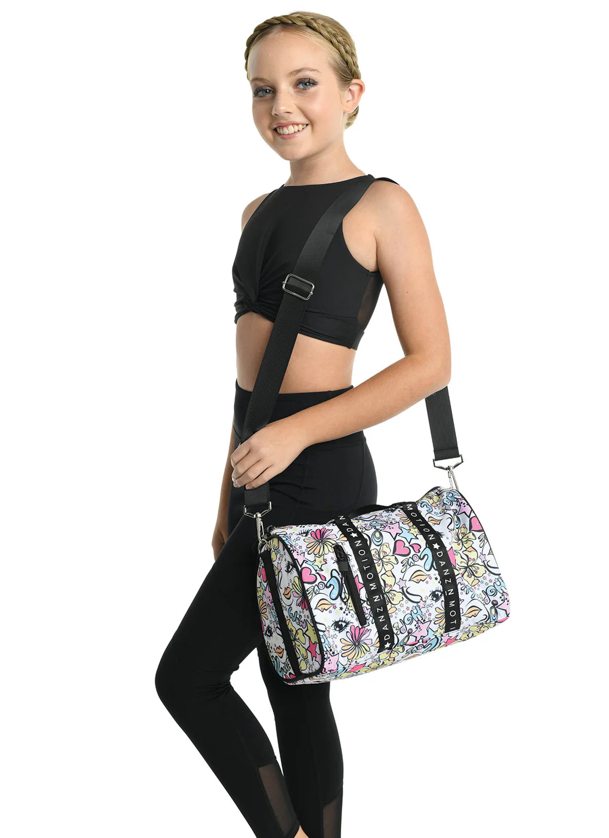 Girl holding Danz N Motion stars and flowers patterned duffel bag with black straps.