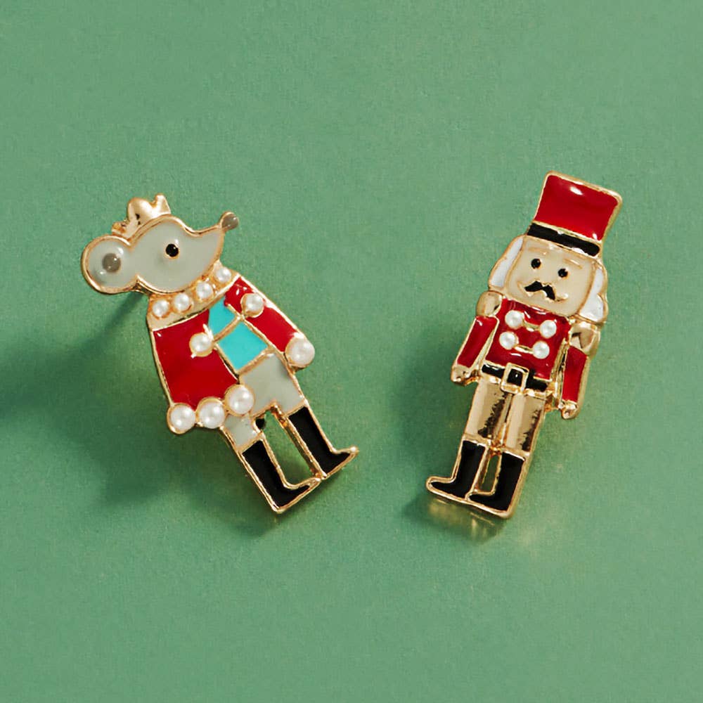 Two small red enamel pin earrings shaped like a nutcracker and a mouse in a military-style uniform.